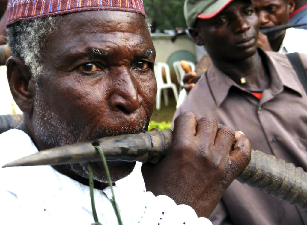 Musiciens africains jouant de cornes lors d une cérémonie — tradition similaire au poungui
